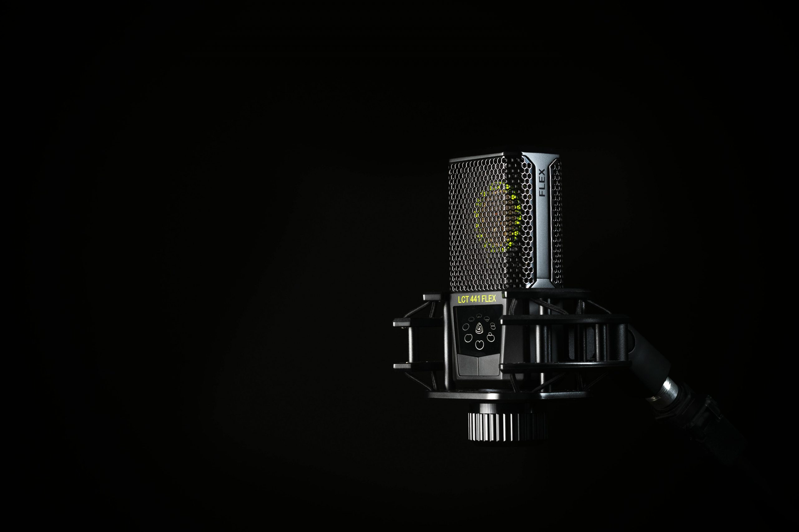 A detailed studio shot of a condenser microphone against a black background, emphasizing modern audio technology.